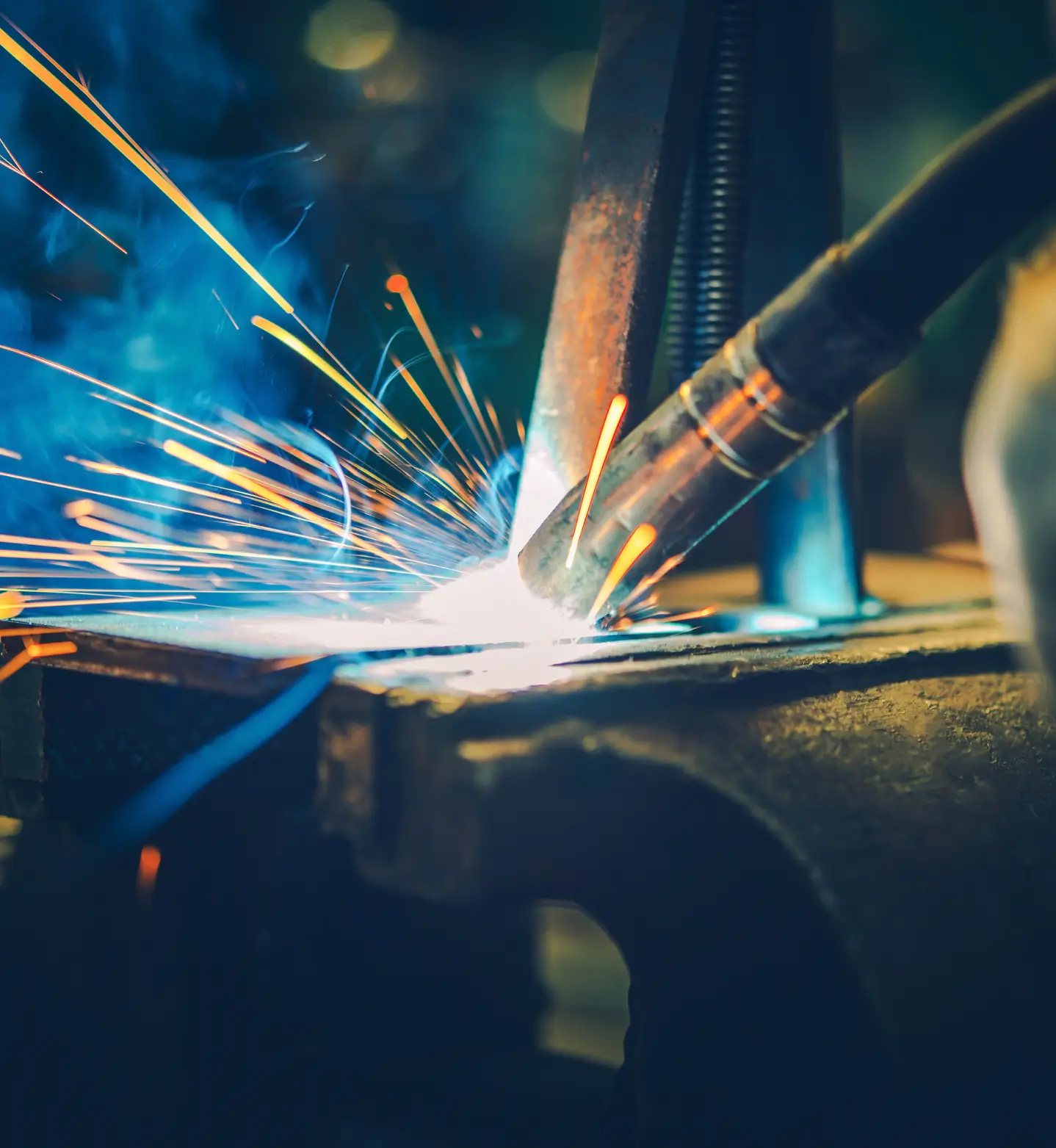 Lasser aan het werk met vonken in een werkplaats